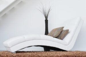Two pillows on a white leather fainting couch
