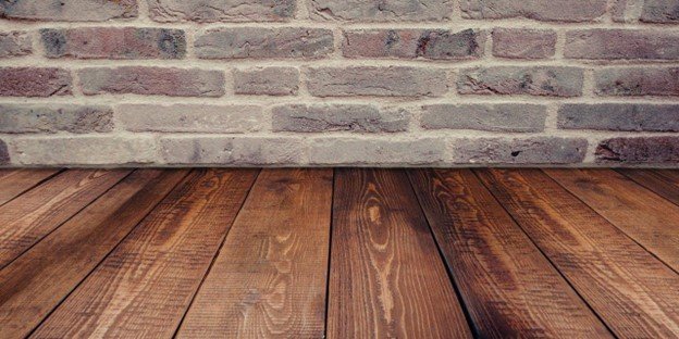 Brown wooden flooring beside a concrete wall