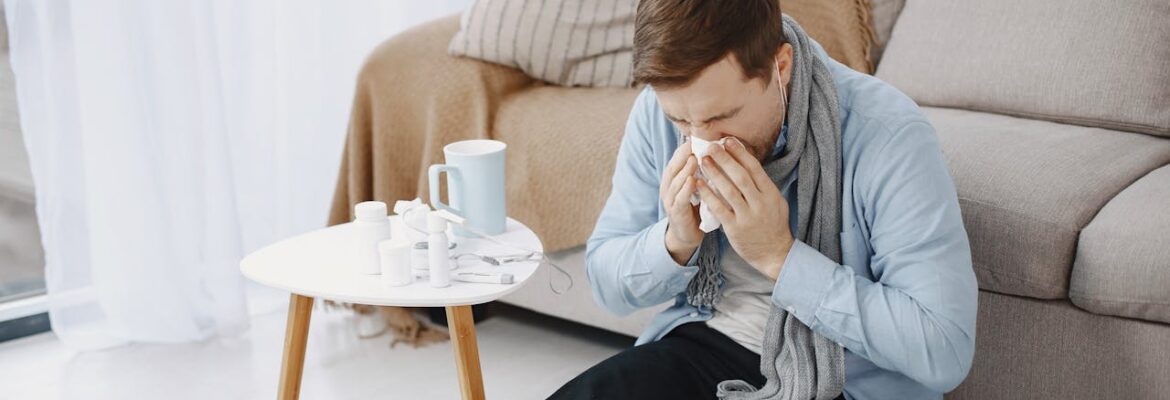 Man sneezing while sitting on the floor